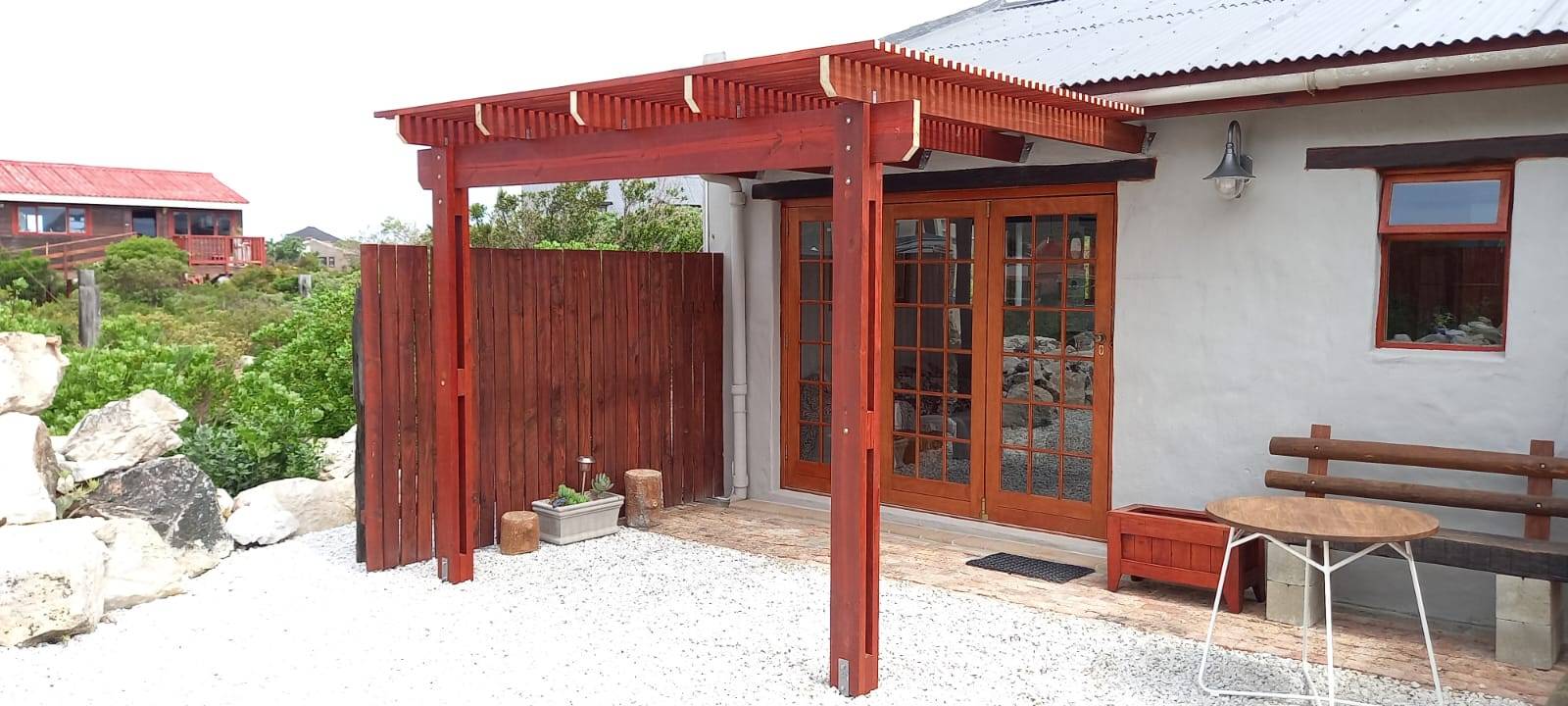 Red pergola matching the house